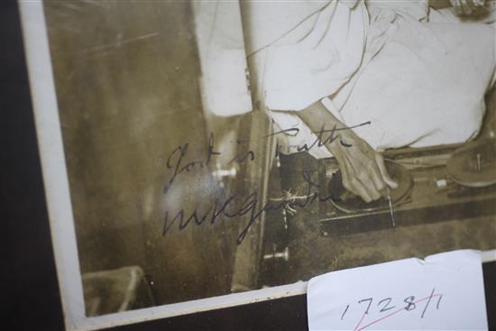 Gandhi, Mohandes Karamchand. An original press photograph of Gandhi seated spinning with a Charka, 20 x 15cms